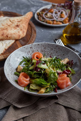 Salmon Salad with spinach, corn salad, baby spinach, fresh mint and basil. Home made food. Concept for a tasty and healthy meal. Dark stone background. Top view. Close up.