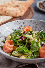 Salmon Salad with spinach, corn salad, baby spinach, fresh mint and basil. Home made food. Concept for a tasty and healthy meal. Dark stone background. Top view. Close up.