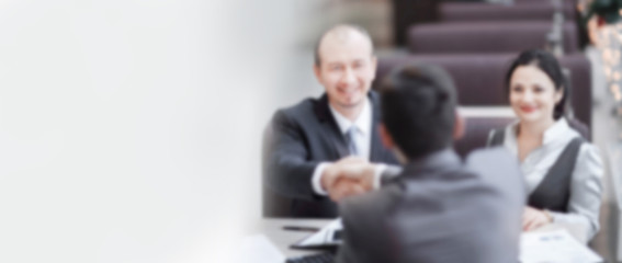 business people shaking hands, sitting at the table