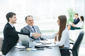 business woman shaking hands with an adult business partner.