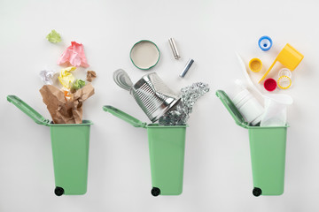 Trash bins and assorted garbage on grey background. Recycle concept
