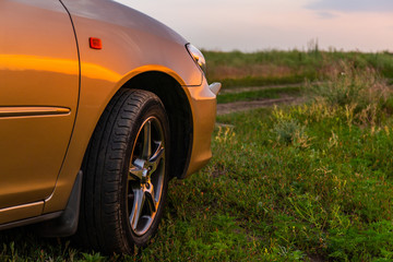 Fototapeta na wymiar Rear-side view of a luxury car on sunset
