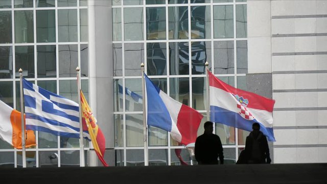 A few persons walking at the European Parliament building in Brussels in spring  