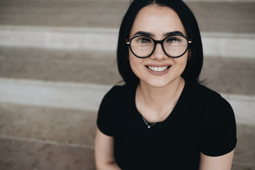 Portrait of Cute Brunette Girl in Black T-shirt in Glasses