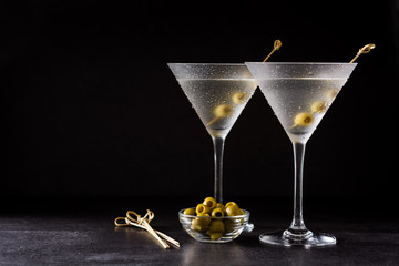 Classic Dry Martini with olives on black background. Copyspace