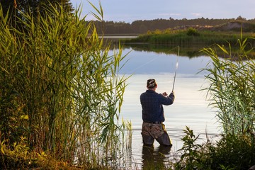 Fototapeta na wymiar Angler catching the fish in the lake