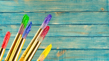 Row of artist paint brushes  on wooden desk background