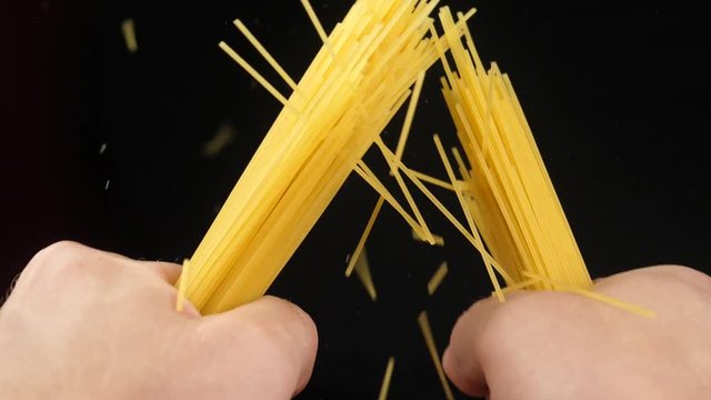 Breaking spaghetti on black background Closeup Slow motion video