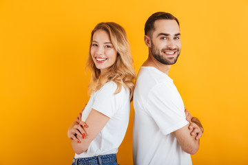 Image of caucasian people man and woman in basic t-shirts smiling while standing back to back