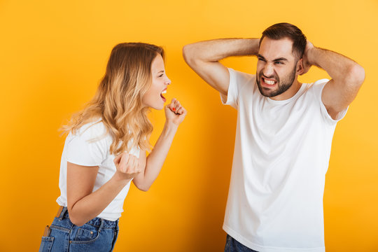 Image Of Annoyed Couple Man And Woman In Basic T-shirts Screaming At Each Other During Fight