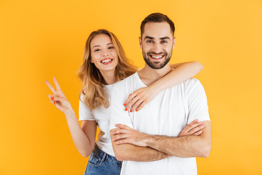 Image of beautiful couple man and woman smiling at camera and showing peace sign