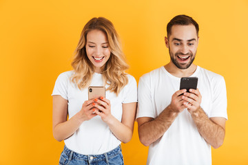 Image of pretty couple man and woman smiling while holding cellphones together