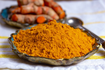 Fresh turmeric or curcuma root and dried powder, wildly used in Asia and India as spice, food ingredient and for medicinal purposes.