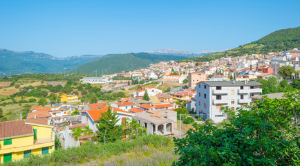 Fototapeta na wymiar View of the colorful town of Oliena on a hill in Sardinia in sunlight in spring
