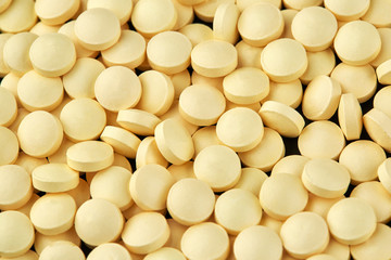 Close-up photo of many yellow pills. Medicine