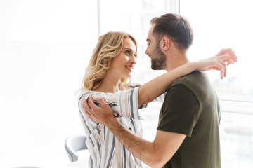 Fototapeta premium Loving couple posing at the kitchen at home hugging.