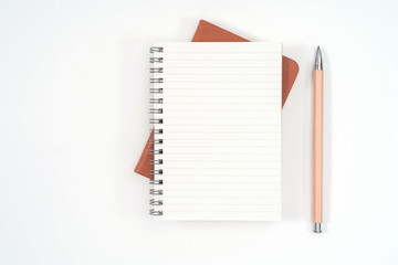 top view blank orange leather diary and pencil on white desk