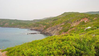 Rocky coast of the island of Sardinia in the Mediterranean Sea in sunlight in spring