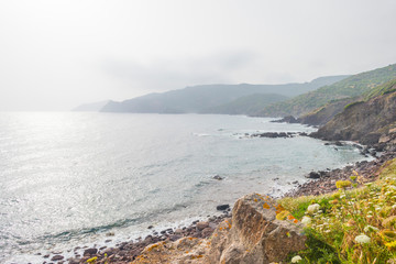 Rocky coast of the island of Sardinia in the Mediterranean Sea in sunlight in spring