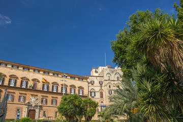 Fototapeta na wymiar Popular tourist royal palace of Palermo Sicily, facade of historical Norman palace and beautiful green trees and palms