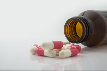 Medical pills spilling out of a toppled from pill bottle