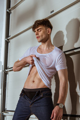 Fototapeta na wymiar sexy muscular man in white t-shirt showing torso