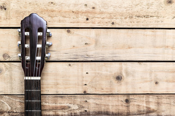 Acoustic guitar on vintage style wood background. Copy space with musical guitar instrument