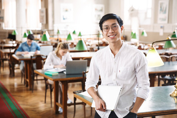 Smart cheerful teenagers studying at the library together