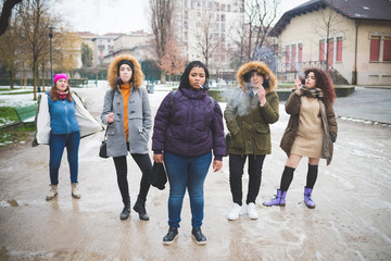group of young women standing in the street and smoking cigarette – multiracial, union,...