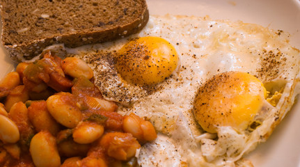 Fried egg with bread and baked white beans in tomato sauce, food