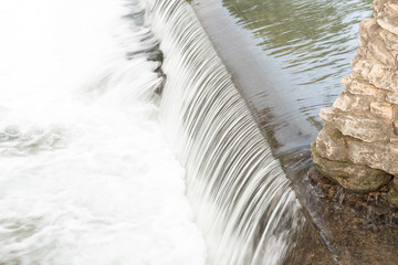 Waterfall in river going to bridge