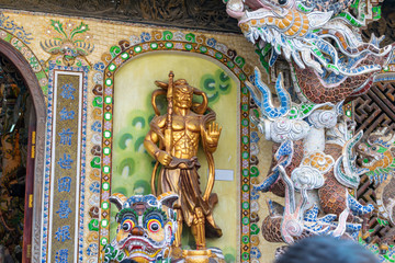 Golden statue of warrior in colorful temple in Vietnam