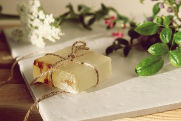 Fototapeta na wymiar Natural soap, plants and berries on a wooden table, spa procedures, body care, healthy lifestyle