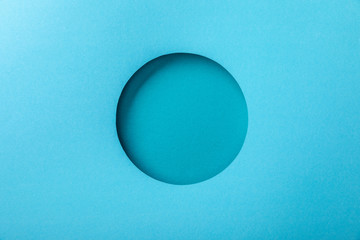 blue paper background with minimalistic round hole - obrazy, fototapety, plakaty