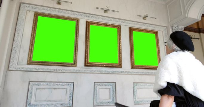 mature woman examines the exhibit in art gallery - Image.