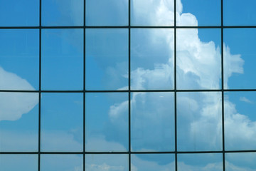 Fototapeta na wymiar Clouds reflected in the glass facade of a skyscraper