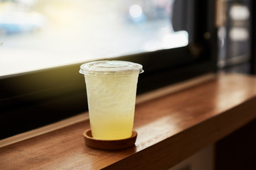Plastic glass of lemon tea for take a way on table in cafeteria.   