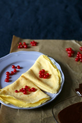 Homemade crepes with chocolate spread and red currants. Selective focus.