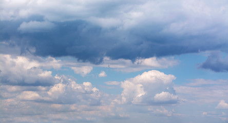 Naklejka na ściany i meble White curly clouds in a blue sky. Sky background 