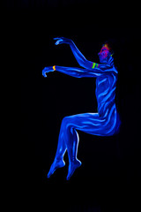 Young naked bodyarted woman in blue glowing ultraviolet paint moving and teasing. Sexy nude girl dancing