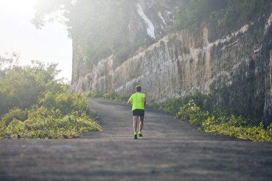 Man Jogging On A Downhill / Uphill In Suburb Mountain Road.