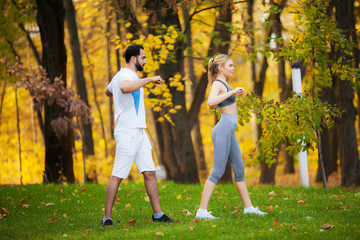 Naklejka na ściany i meble Fitness. Personal Trainer Takes Notes While Woman Exercising Outdoor