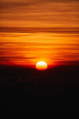 Sunrise / sunset over the clouds and horizon in golden colors.