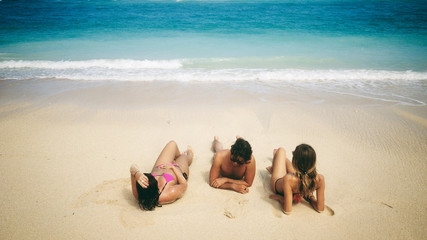 Fototapeta na wymiar Friends enjoying on a sandy tropical ocean / sea beach.