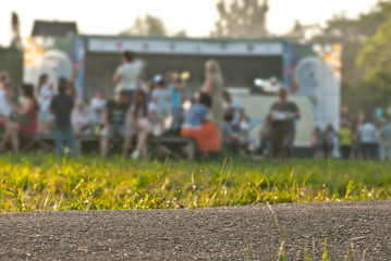 Asphalt and grass in sharp contrast to the background of blurred people. Ethnofestival for music.