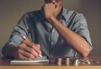 Businessman taking notes and stack of coins to create an account, Business ,save money concept.