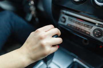 Woman switches the automatic transmission's close-up. Close-up of the driver's adm includes mode Drive on the gear lever automatic transmission of the car interior parts