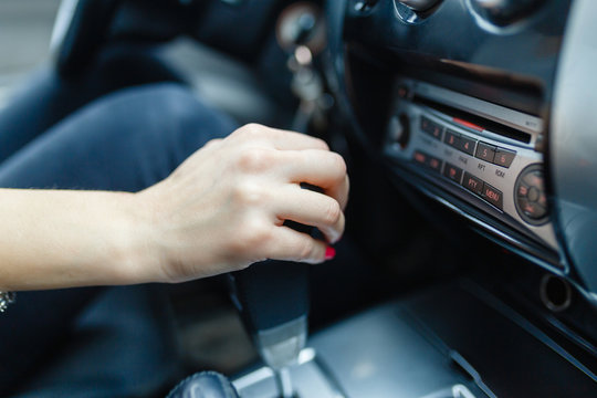 Woman switches the automatic transmission's close-up. Close-up of the driver's adm includes mode Drive on the gear lever automatic transmission of the car interior parts