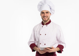 Portrait of a happy male chef cook showing blank tablet computer screen isolated on a white background.