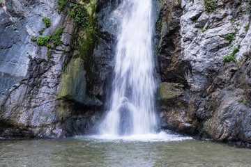 Fototapeta na wymiar Silhouette of person cooling off under Eaton Falls in the San Gabriel Mountains near Pasadena in Southern California. 